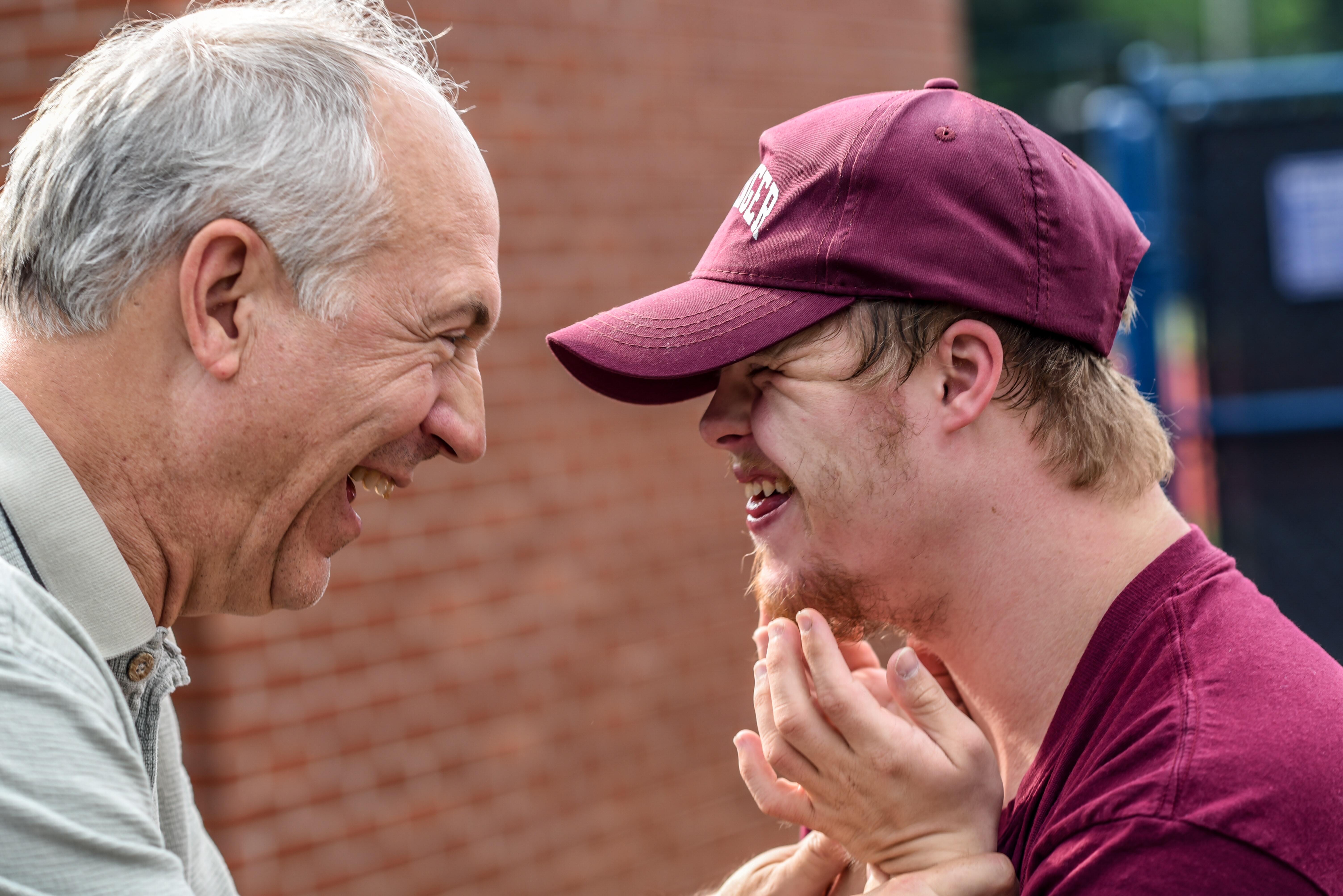 one old and one young man laughing